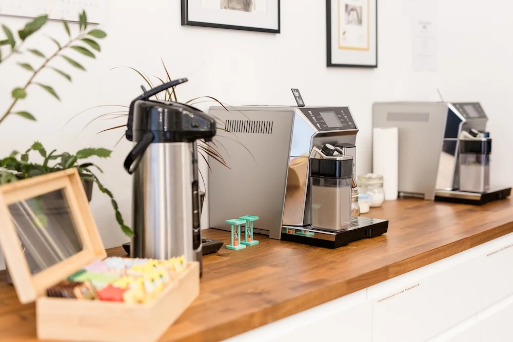 Zeigt unsere Kaffee- und Teebar mit Teebox, Thermoskanne und 2 Kaffeemachinen